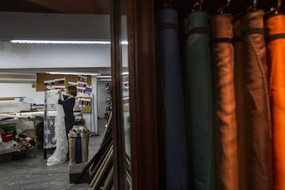 Una treballadora de Gratacós darrere algunes de les teles de la botiga, que formen una petita paleta de colors.
