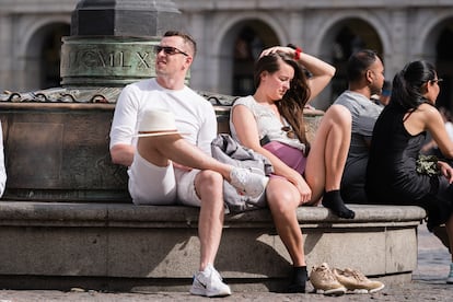 Dos personas se sientan al sol, este lunes en Madrid.