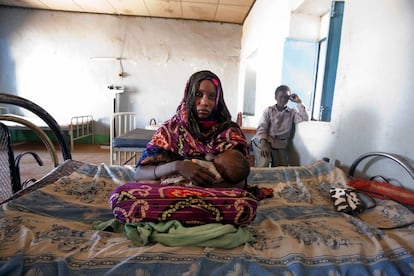 Una sudanesa procedente de Libia amamanta a su hijo en un puesto de control a las afueras de Malha (Darfur) el 7 de marzo de 2011. Darfur espera la llegada de 2.000 mujeres y niños huidos de Libia en los próximos días.