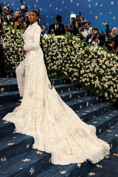 Şarkıcı Coco Jones, uzun kuyruklu beyaz pantolon takımı ve redingot giyiyor. Jimmy Choo ayakkabılarıyla kombinlediği Manish Malhotra tasarımı.