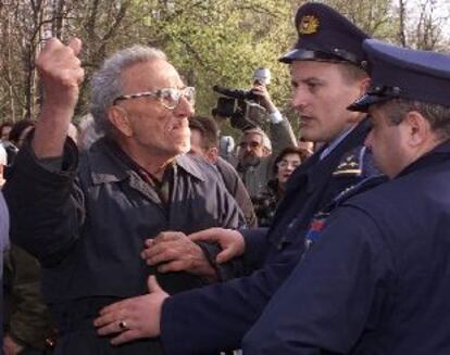 Un manifestante partidario de Milosevic amenaza a la policía a las puertas de la residencia del ex dictador en Belgrado.