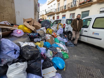 Un vecino de El Puerto pasa junto a la basura acumulada junto al mercado de abastos de la ciudad el pasado 7 de marzo, día en el que se desconvocó la huelga tras 11 días de paro.