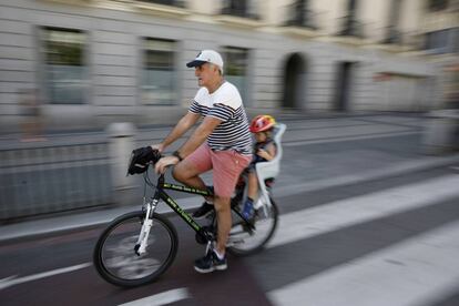 Un se&ntilde;or mayor circula con un ni&ntilde;o peque&ntilde;o en el transport&iacute;n por el carril bici de la calle de Alcal&aacute; de Madrid. 