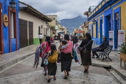 Un grupo de mujeres y niños caminan por un andador peatonal en San Cristóbal de las Casas, Chiapas, muchas artesanas viajan desde sus comunidades para vender sus piezas a turistas de esta ciudad.