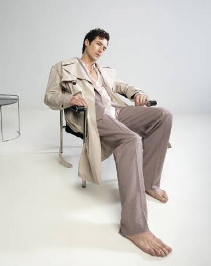 Jorge Suquet se abandona sobre una silla con gabardina Givenchy y traje y camisa Hugo. Colgante con sello Súarez.