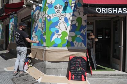 El artista barcelonés David Malolargo pinta su obra ‘Bad Welcome’ en un bar de la calle Argumosa, Madrid.