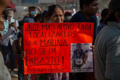 Una mujer lleva un cartel exigiendo la búsqueda de los dos niños desaparecidos a bordo del 'Rosemary Christine', el 18 de noviembre.