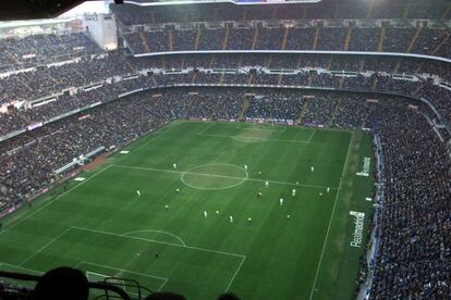 Tras la construcción de las nuevas estructuras la altura del estadio pasó de 22 a 45 metros. Esto supuso que una gran parte de las gradas y del césped se quedaran en sombra. En la imagen, una vista aérea panorámica del estadio Santiago Bernabéu durante un partido de fútbol del Real Madrid, de la temporada 2001-2002, en la que se aprecia el estado del césped del terreno de juego.