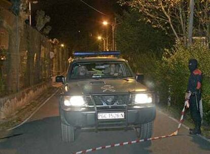 Un <i>ertzaina</i> abre paso a un vehículo de la Guardia Civil anoche en el lugar del tiroteo.