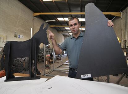 El artista Fernando Sánchez Castillo posa junto a la maqueta de <i>Burro Grande</i> en el taller de la fundición Capa.