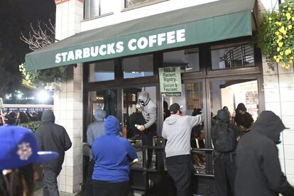 Manifestantes vandalizan una cafetería durante una protesta contra el escritor ultraderechista Milo Yiannopoulos en Berkeley.