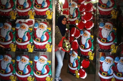 Una mujer palestina sale de una tienda decorada con adornos navideños, en Gaza.