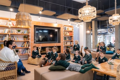 Unos jóvenes alumnos del Colegio Europa, en Getxo (Bilbao), escuchan a su profesora en uno de los espacios polivalentes del centro.