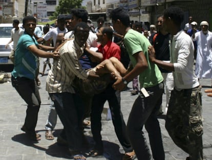 Manifestantes antigubernamentales trasladan a un herido durante los choques con la policía en Adén.