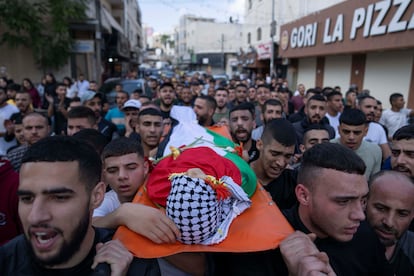 Mourners carry the body of Ayham Shafe'e, 14, during his funeral in the West Bank city of Ramallah