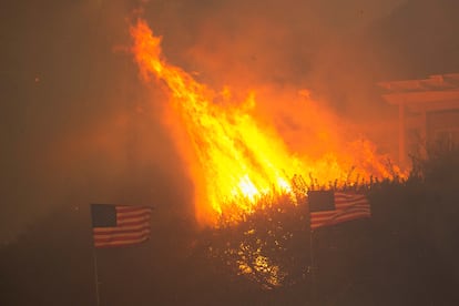 Las llamas avanzan sobre una zona residencial en medio de una tormenta de viento en el lado oeste de Los Ángeles, California.