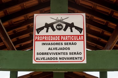 Uma placa no clube de tiro adverte que os invasores serão alvejados e os sobreviventes também. 
