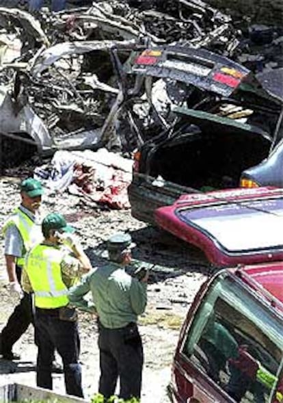 Los agentes asesinados yacen cubiertos con sábanas en medio de los destrozos causados por la bomba.