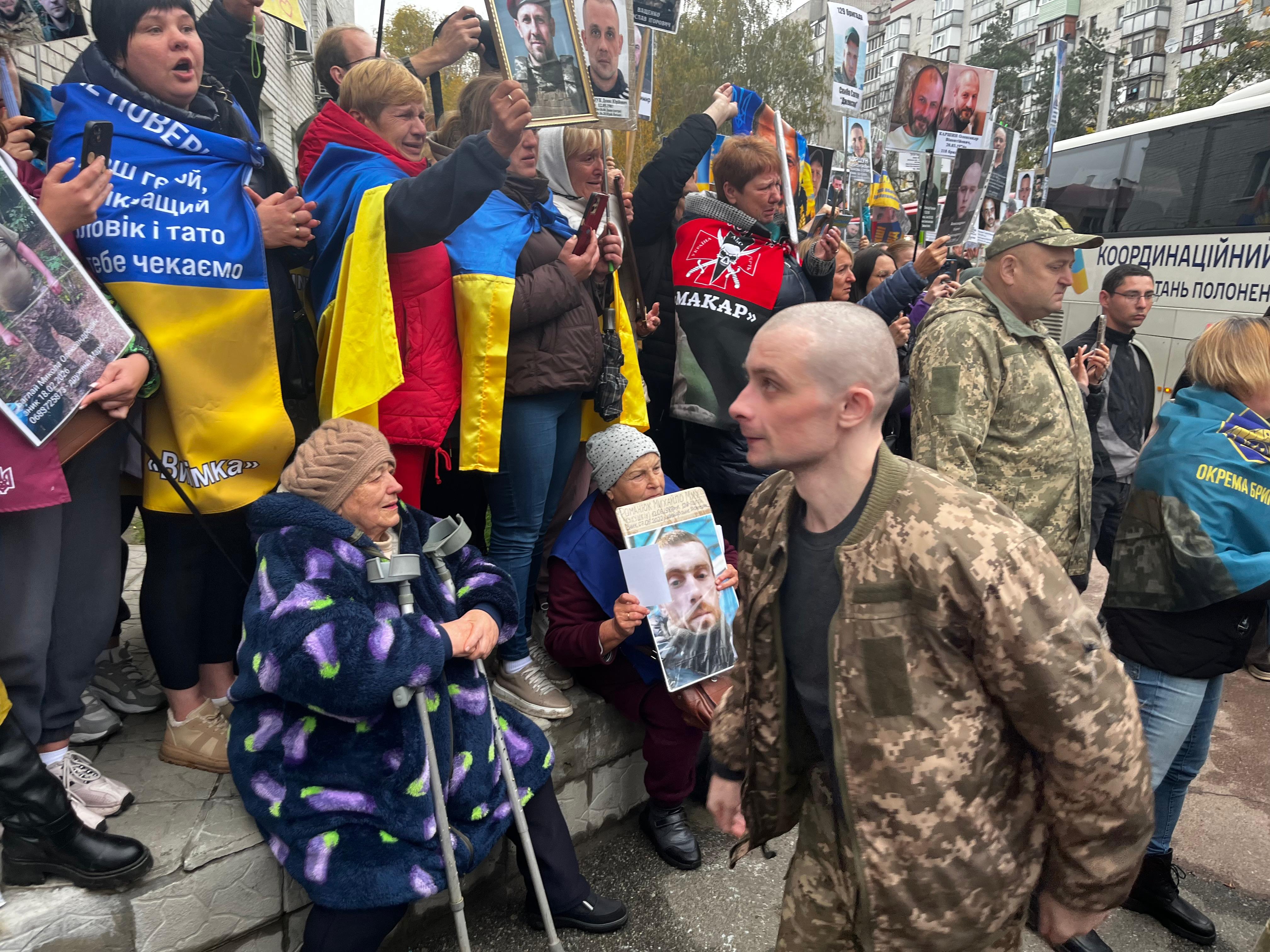 Decenas de personas con fotos de desaparecidos ante la llegada de prisioneros ucranios recién liberados por Rusia este jueves.