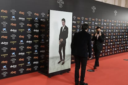 Casas, que se ha hecho este año con el Goya a mejor actor, ha participado en remoto con esmoquin y camisa blanca con jaretas y sin pajarita, una fórmula que recuerda a la que eligió en los recientes premios Feroz. Durante las primeras conexiones lo combinó con unas pantuflas de Batman –él mismo lo confesó durante una entrevista en directo–, pero en las imágenes oficiales aparece con unos elegantes 'slippers' sin calcetines.