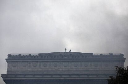 Dos 'chalecos amarillos' se suben a la parte más alta del Arco del Triunfo durante las protestas en París.