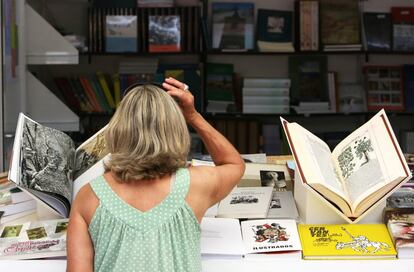 Una asistente observa los libros de una de las casetas.