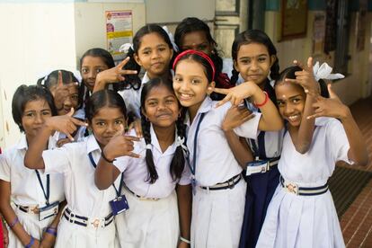 Niñas saludan a la entrada del colegio en Cochin. Según los parámetros de la UNESCO, la educación universal conseguida por Kerala supone que el 90% de la población de estudiantes están inscritos en los colegios de la región del sur de India.