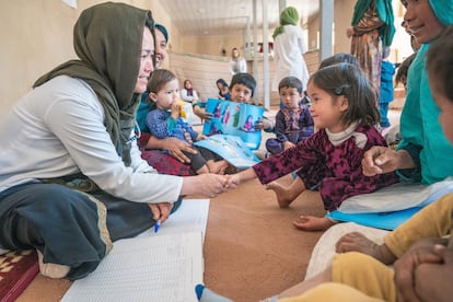 Fatima Adeli, doctora de un equipo móvil de salud y nutrición, saluda a un paciente en la aldea de Safeedi-Mish, en el distrito de Nili, en el centro de Afganistán.  

El equipo móvil itinerante de salud y nutrición proporciona un salvavidas a comunidades inaccesibles que, de otro modo, no podrían acudir a los dispensarios. 

"La mayoría de los casos que veo son de gripe y enfermedades de garganta. También hay mucho cólera y, como madre, me entristece", afirma la doctora. "Como aquí tengo muchos medicamentos y puedo tratar fácilmente a los niños, paso de estar muy triste a alegrarme rápidamente porque sé que mis pacientes mejorarán.  Siempre duermo bien al final de un día muy largo".