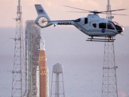 Un helicóptero de la NASA sobrevuela cerca del cohete SLS, durante la cuenta atrás.