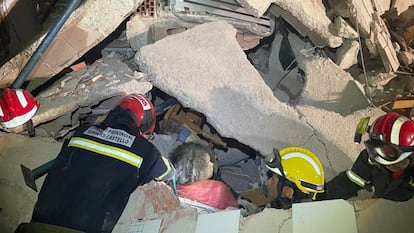 Los bomberos rescatan con vida a una de las tres personas sepultadas.