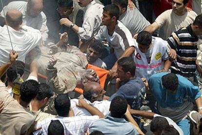Varios palestinos trasladan el cadáver de uno de los muertos de Hamás.