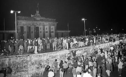 Cidadãos dos dois lados de Berlim celebram sobre o Muro a abertura da fronteira em 9 de novembro de 1989.