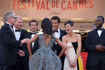 El delegado general del Festival de Cannes Thierry Fremaux (i) da la bienvenida a la actriz Zoe Saldana (espaldas) y a los actores Noah Emmerich (2i), French director Guillaume Canet (3i), el actor británico Clive Owen (3f), Marion Cotillard (2d) y el actor Jamie Hector (d), antes del estreno de la película 'Blood Ties' presentada fuera de competición en el Festival de Cannes.