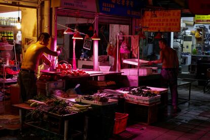 Pero la ciudad también encapsula las disparidades de la China moderna. A la vista del reluciente distrito central de negocios se encuentran los restos de las "aldeas urbanas" de Guangzhou, como Xiancun. En la imagen, trabajadores en un mercado en Yuexiu, Guanghzou (China).