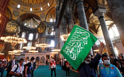 Un hombre sujeta una bandera islámica mientras visita la mezquita de Santa Sofía, tras el rezo del viernes.
