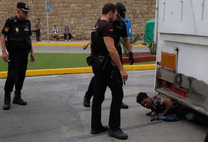 Agentes de la Policía Nacional sacan a un inmigrante de un camión con atracciones de feria en Melilla.
