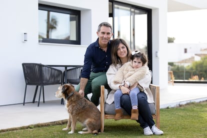 Carmen, en brazos de su madre, Laura Bergillos, con su padre, Javier Silva, y su perra Lua, en el jardín de su casa de Benalmádena (Málaga) a principios de mes.