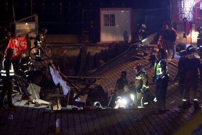 Los bomberos trabajan en la pasarela que se desplomó anoche en Vigo.