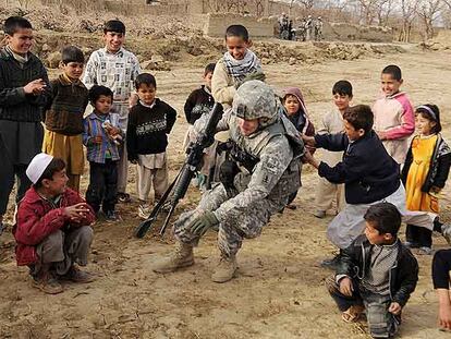 Un soldado de EE UU asignado a las fuerzas de la OTAN en Afganistán juega con unos niños en Bagram (norte del país).