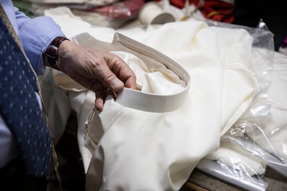 Raniero Mancinelli holds a collar at his store on Via Borgo Pio in Rome, near Vatican City.