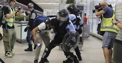 Enfrentamiento entre la policía y los manifestantes en el aeropuerto de Hong Kong.