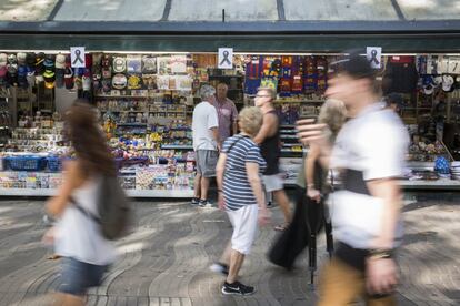 Varios lazos negros cuelgan de uno de los quioscos de las Ramblas en Barcelona tras el atentado ocurrido ayer por la tarde en el que una furgoneta arrolló a los peatones que paseaban por la zona.