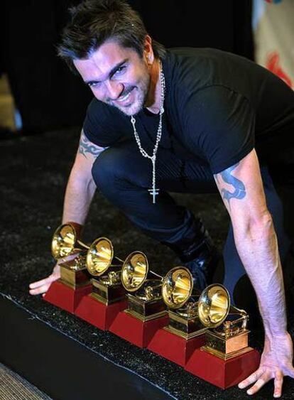 Juanes exhibe sus cinco premios.