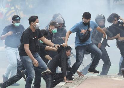 Agentes de policía detienen a manifestantes durante un mitin en Yakarta (Indonesia). La tercera jornada de protestas en el país contra una reforma legislativa que, según los manifestantes, recorta derechos laborales y amenaza el medio ambiente, estuvieron marcadas por enfrentamientos con la policía, que detuvo a 150 personas en la capital.