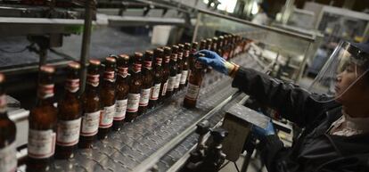 Una persona trabaja en la línea de embotellado en una fábrica de cerveza de la multinacional Anheuser-Busch InBev.