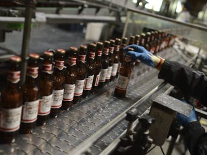 Una persona trabaja en la línea de embotellado en una fábrica de cerveza de la multinacional Anheuser-Busch InBev.