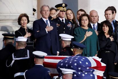 O ex-presidente dos Estados Unidos George W. Bush, filho do também ex-presidente George H.W. Bush, e sua esposa Laura observam os militares carregarem o caixão em Washington