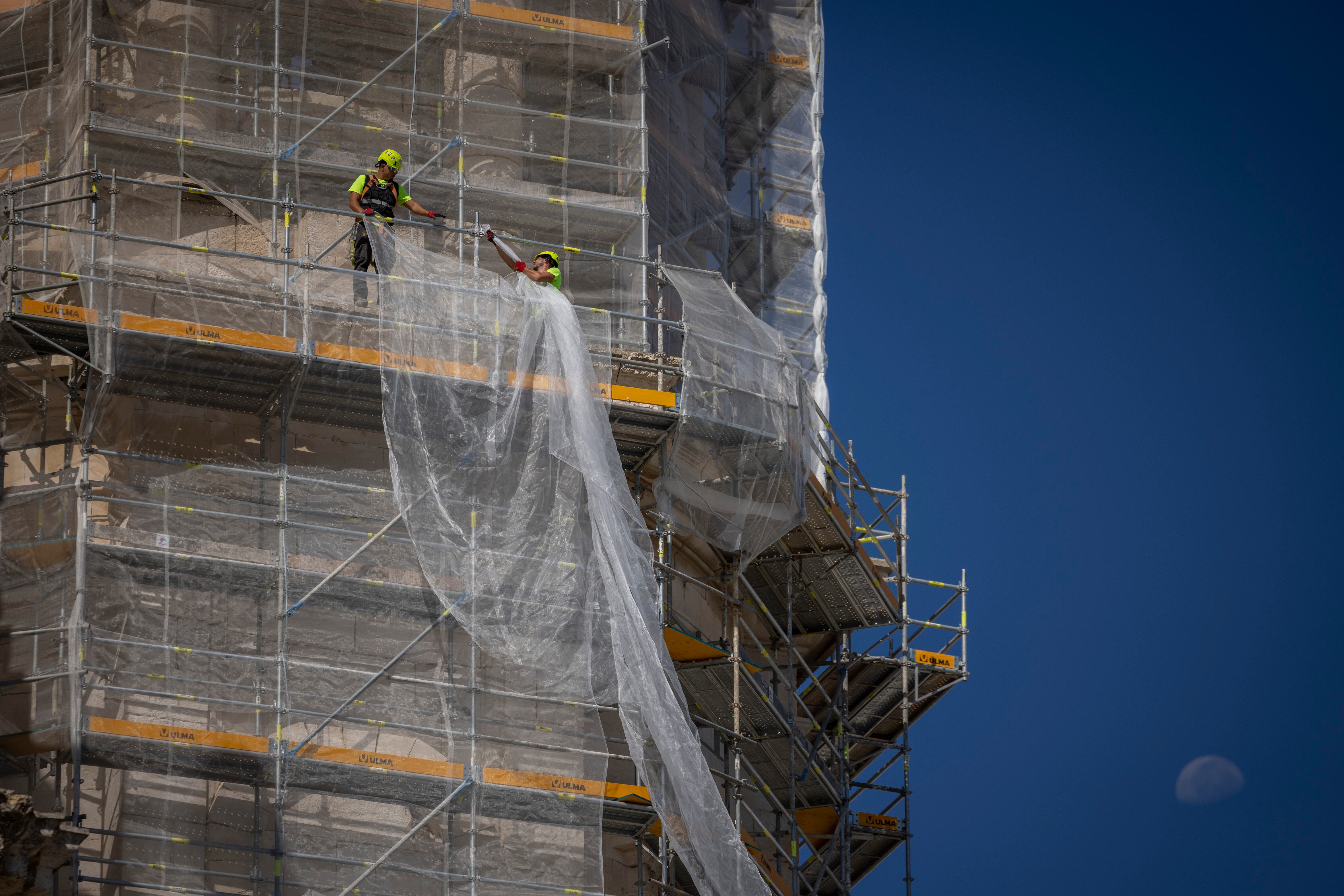 Trabajadores en un andamio de una obra en la Catedral de Cádiz, el 4 de agosto