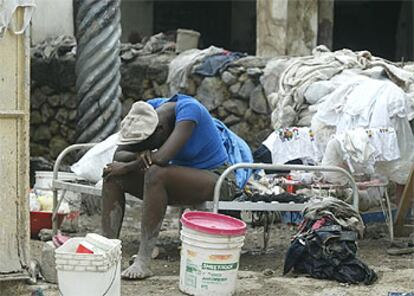 Una mujer descansa sentada en una cama en una calle de Gonaives, al noroeste de Haití.
