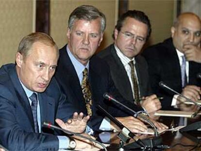 Putin (izquierda) se dirige a varios empresarios extranjeros durante un encuentro en Moscú.